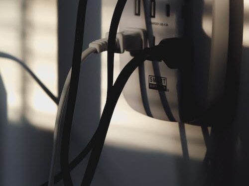 Plug cords going into a power outlet.